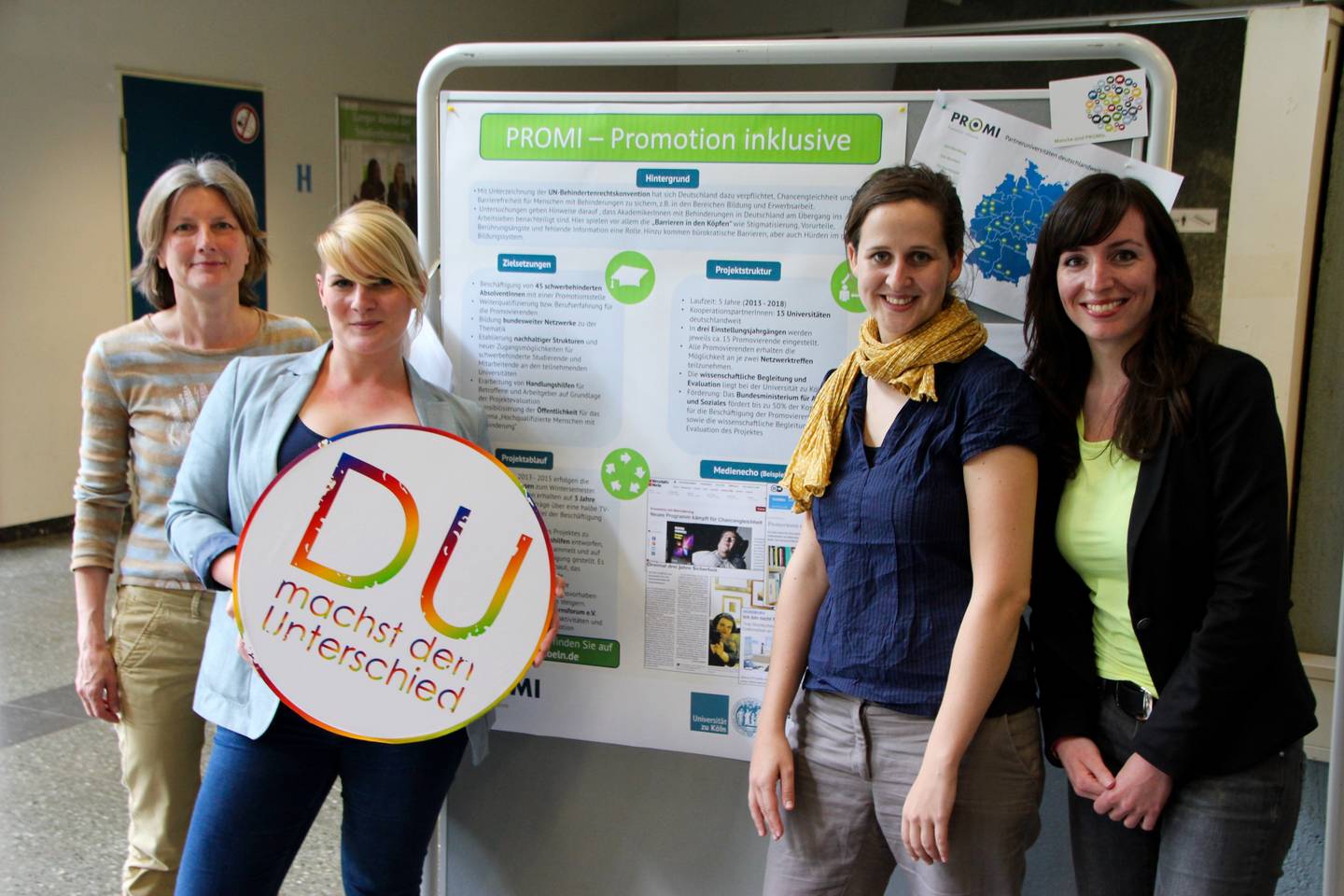 Die Mitwirkenden des Projekts Promotion Inklusive halten das Logo der Themenwoche "Du machst den Unterschied"