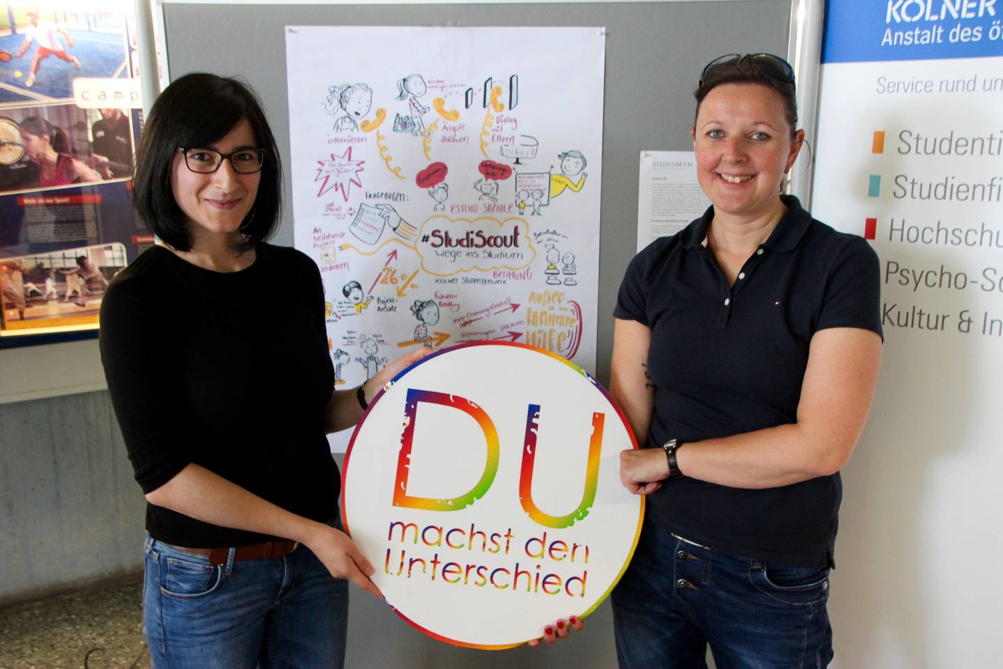 Zwei Organisatorinnen des StudiScouts, die das Logo der Themenwoche "Du machst den Unterschied" gemeinsam in den Händen halten.