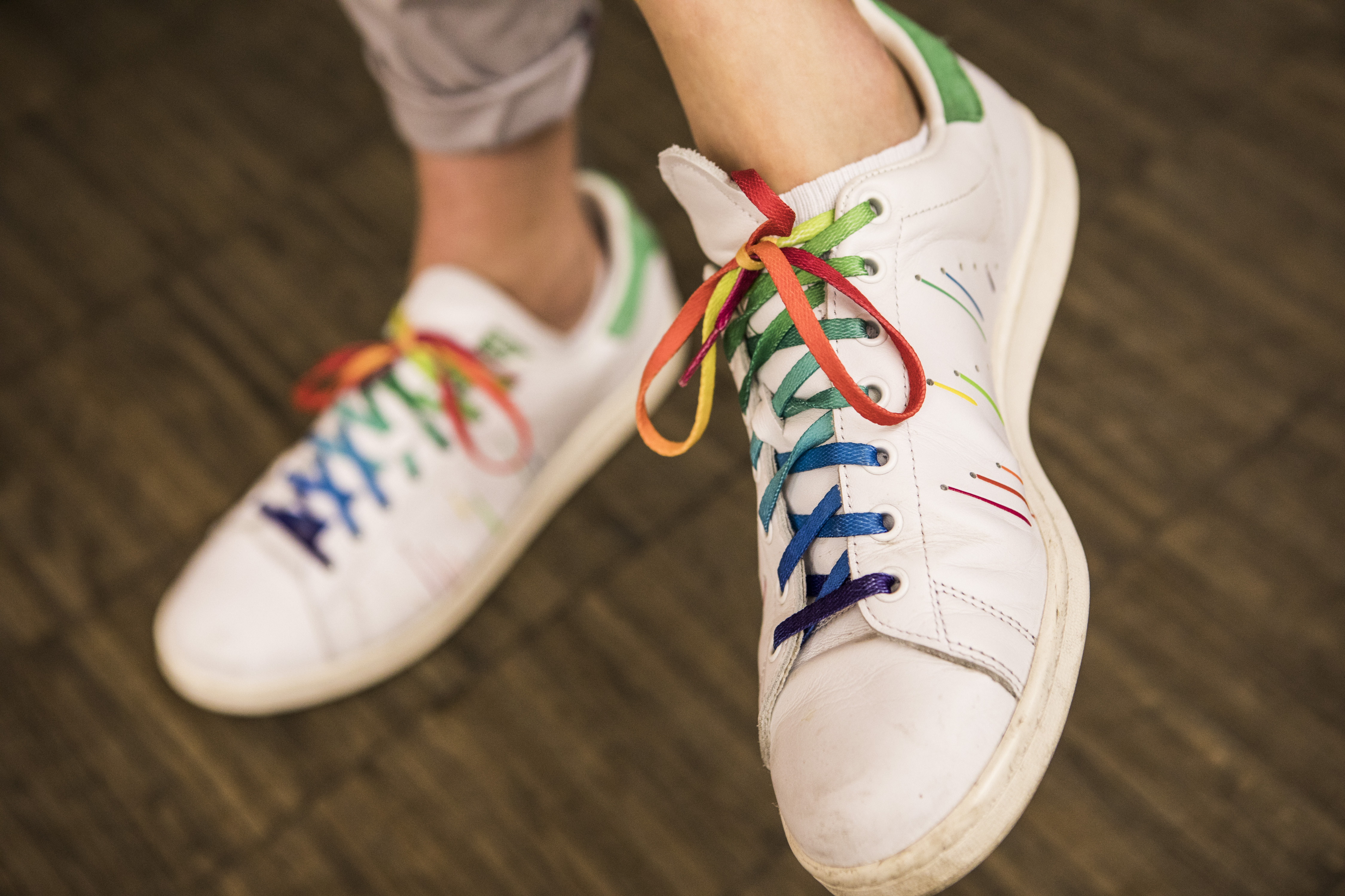 Detailaufnahme Schuhe mit Schnürsenkeln in Regenbogenfarben.