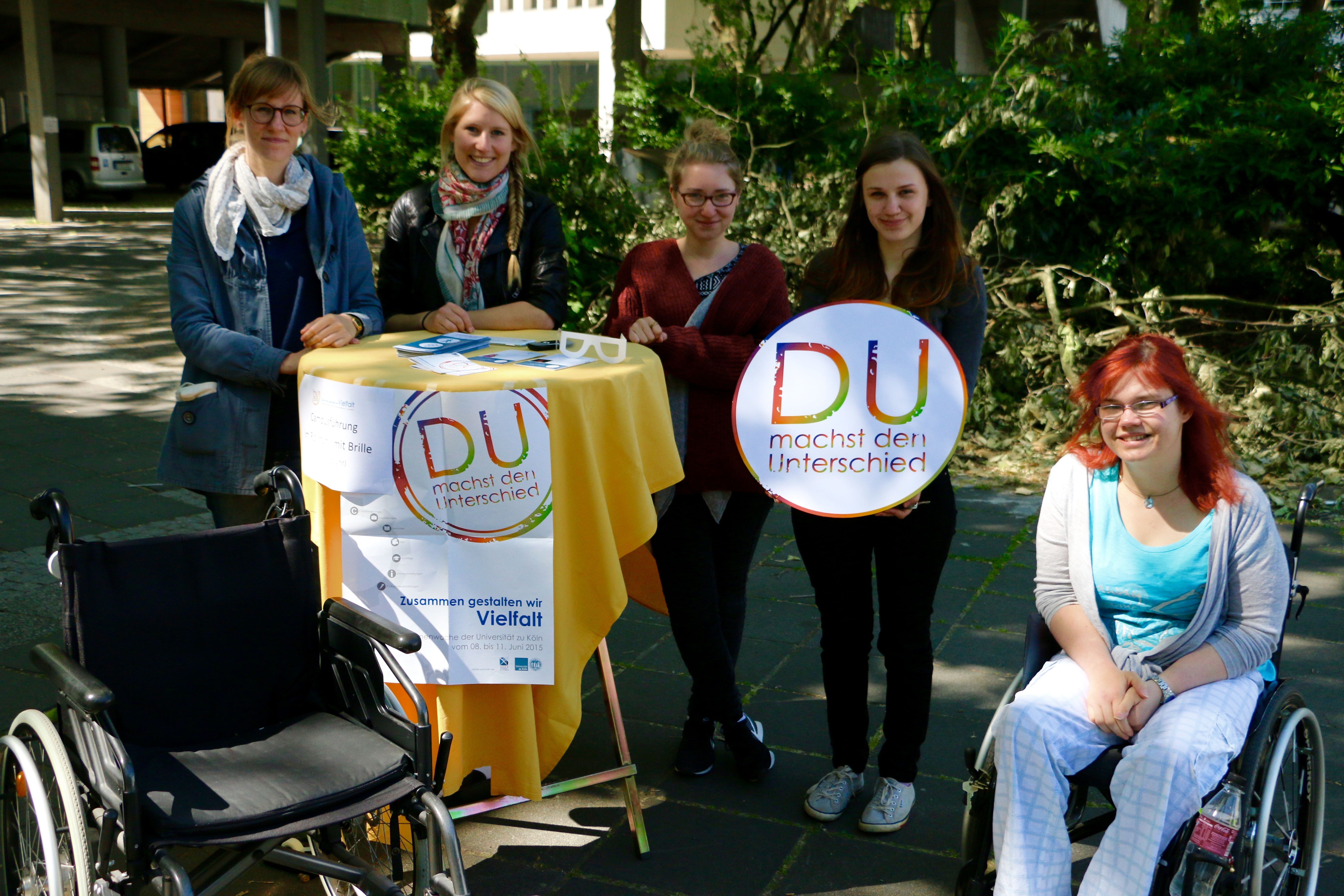 Das Team des Servicezentrum Behinderung und Studium auf dem Albertus Magnus Platz zusammen mit dem Logo der Themenwoche "Du machst den Unterschied" in den Händen
